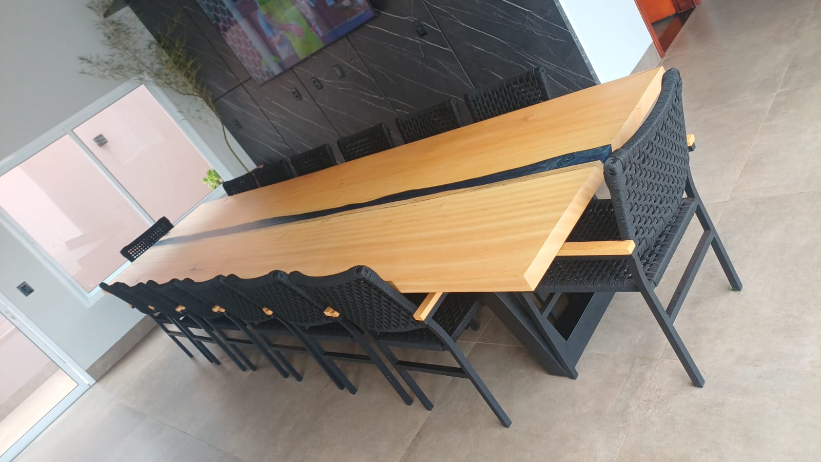 Mesa de jantar em madeira clara com detalhe em resina